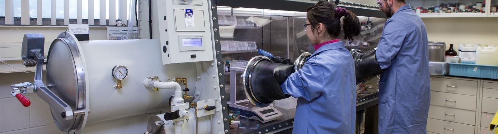 化学专业的学生在实验室里使用设备处理物质.